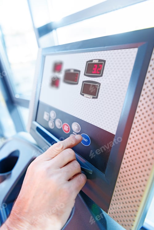 Preview: Close-up partial view of hand and interface of fitness machine in gym