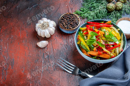 Preview: top view vegetable salad in bowl ultramarine blue shawl garlic black pepper fork on dark red table