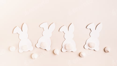 Preview: Happy Easter white decorative bunnies and mini meringues on pink background top view web banner