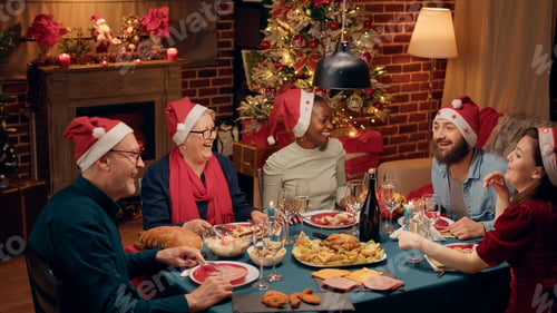 Preview: Cheerful laughing heartily multiethnic family toasting sparkling wine while singing Christmas songs