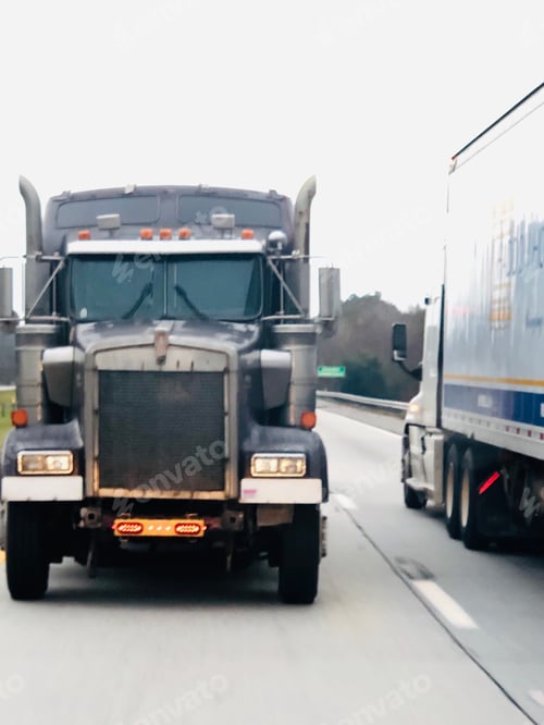 Preview: Two truck beside each other, the truck on the left is being towed.