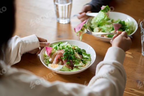 Preview: Asian woman eating salad at lunch