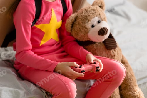 Preview: Partial view of kid with teddy bear holding gamepad