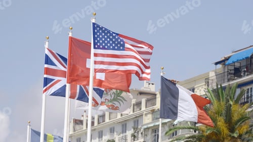 Preview: Row of waving flags of different countries. Action. Concept of politics, waving flags on a blue sky