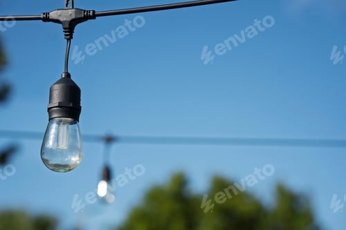 Preview: Outdoor string light against blue sky.