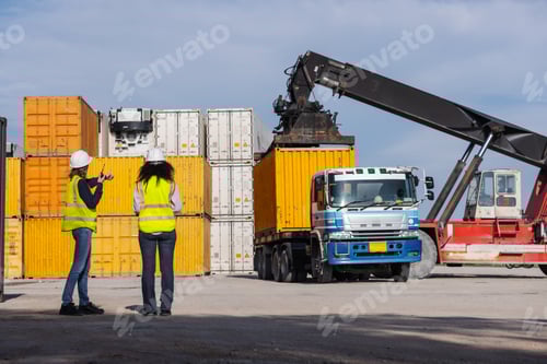 Preview: Two female workers oversee container loading operations at a shipping yard.
