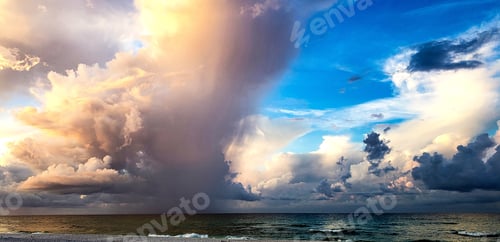 Preview: Beach landscape with colorful cloudscape over ocean after sunrise in tropical vibes at sea.