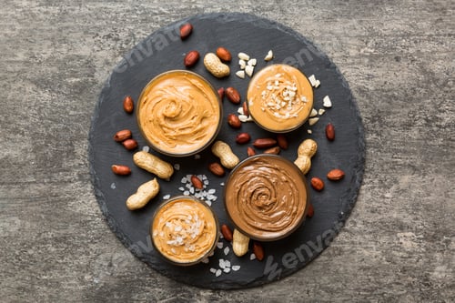 Preview: Glass jar with peanut butterin plate on table background, top view space for text and close up