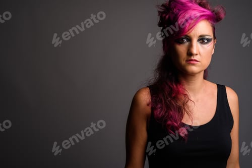 Preview: Beautiful woman with pink hair and make-up against gray backgrou