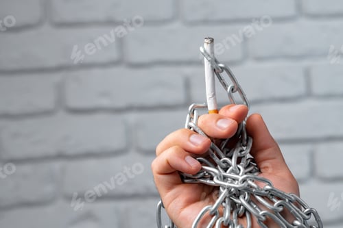 Preview: Male hand in metal chains holding cigarette