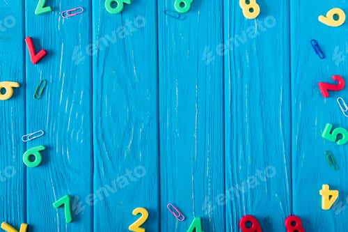 Preview: top view of colorful various numbers and paper clips on blue wooden background