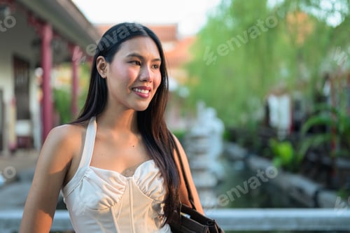 Preview: Young Asian woman in traditional Asian garden park during summer