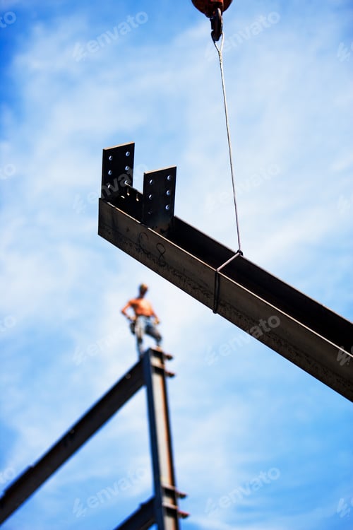 Preview: Construction worker guiding a steel beam into place