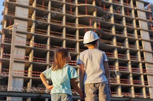 Preview: Children, a boy and a girl, are looking at the construction of a multi-storey building.