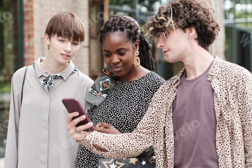 Preview: Friends using mobile phone outdoors