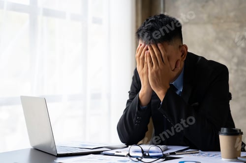 Preview: tired businessman sleepy and bored from sitting at a desk for a long time and has office syndrome