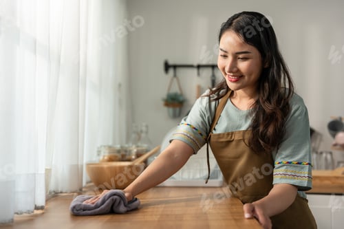 Preview: Asian beautiful cleaning service woman worker cleaning kitchen at home.