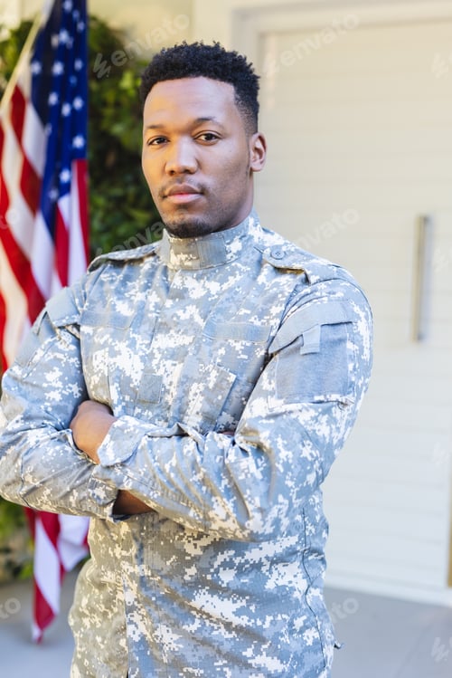Preview: African american male soldier standing with arms crossed outside home with usa flag, copy space