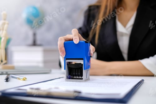 Preview: Close up of businesswoman hands approve documents stamp at the office.