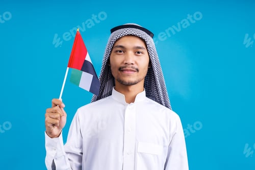 Preview: Young Arab Man Holding United Arab Emirates Flag On Blue Background