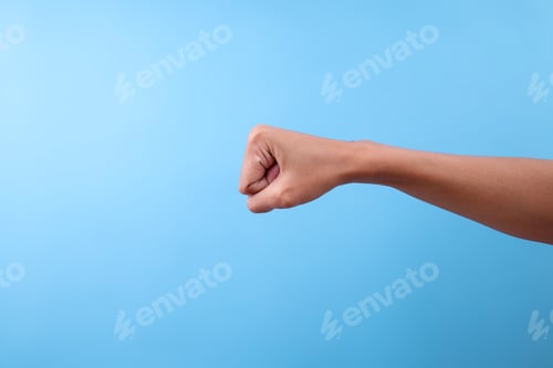Preview: Clenched Fist Showing Symbol Of Strength Or Punch Over Light Blue Background