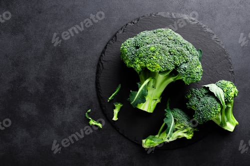 Preview: Fresh broccoli florets on black background, top view