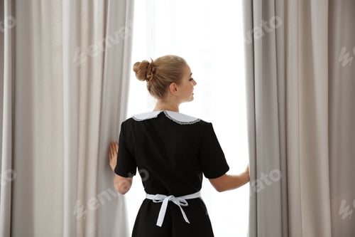 Preview: Young maid opening curtains in hotel room