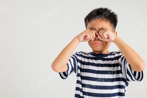 Visualização: A
turbulência emocional de um garoto asiático se desenrola quando chora e enxuga as lágrimas com os dedos. Isolado em