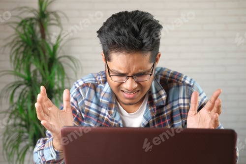 Preview: young stressed businessman working on laptop