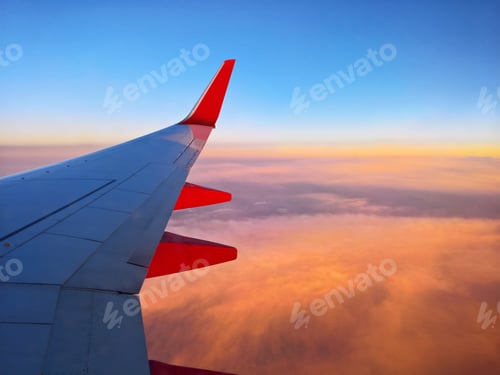 Preview: Airplane wing over the sunset sky with beautiful golden clouds