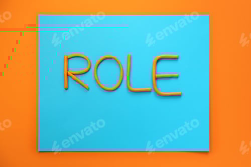 Preview: Word Role made with plasticine on orange background, flat lay