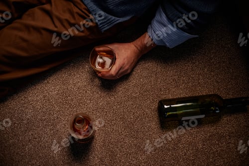 Preview: Holding Half-Empty Glass While Sitting on Carpeted Floor