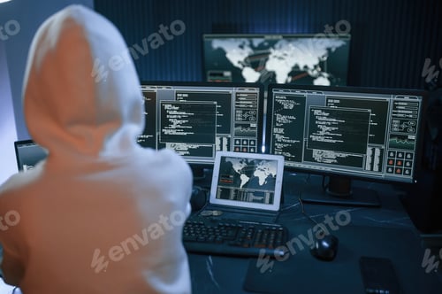 Preview: Young professional female hacker is indoors by computer with lot of information on displays