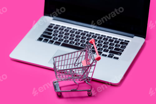 Preview: beautiful shopping cart and cool laptop on the wonderful pink background