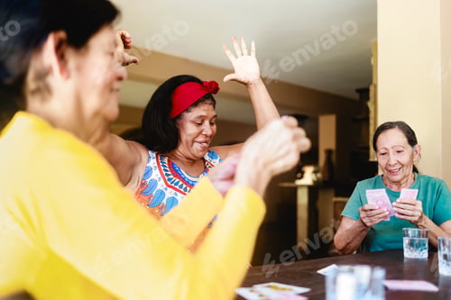 Preview: Happy senior women having fun playing cards at home. Elderly people life style
