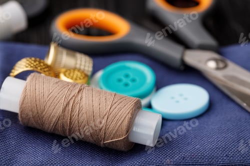 Preview: Colorful sewing utensils on black wooden surface