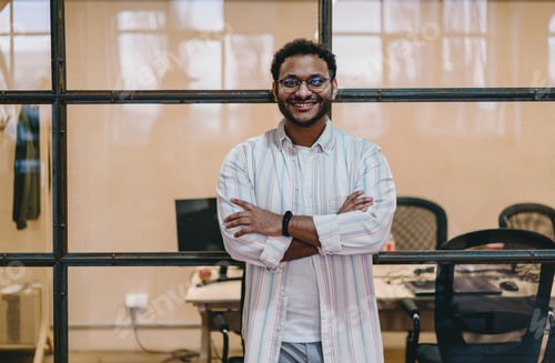 Preview: Positive Hispanic man standing near wall of office