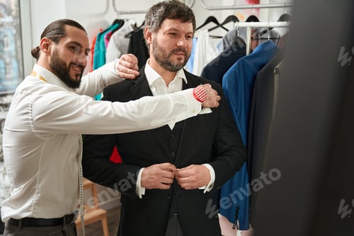 Preview: Man Getting Fitted for Bespoke Suit by Tailor