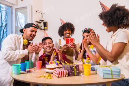 Preview: friends at a birthday party on the sofa at home with a cake, placing the happy brithday candles