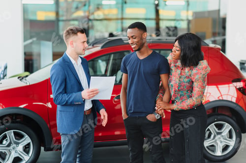 Preview: young african couple buying new car at dealership