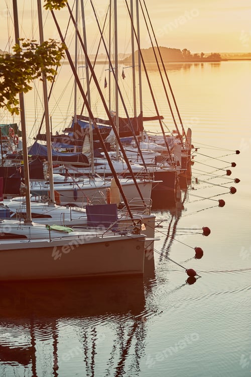 Preview: Yachts and boats moored in a harbour at sunrise. Candid people, real moments, authentic situations