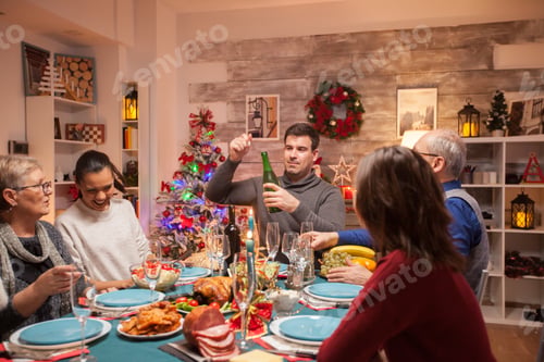 Preview: Happy father opening a bottle of wine