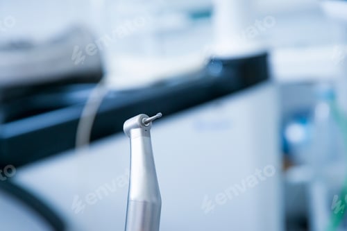 Preview: Dentist instruments. Dental diamond cylinder bur with hand-piece. Blurred dental office background