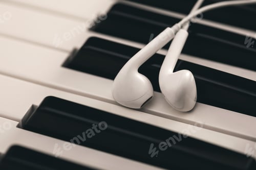 Preview: Closeup of earphones over piano or synthesizer keyboard