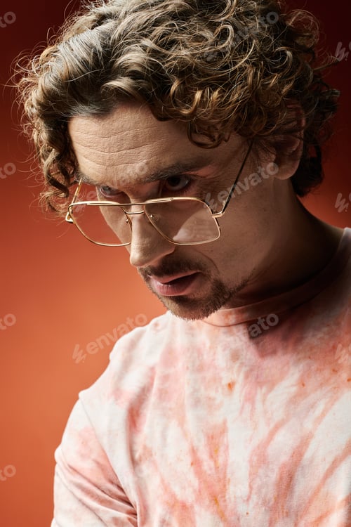 Preview: Handsome Emotional Man Posing Against a Vibrant Orange Backdrop
