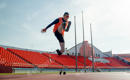 Preview: Sport man athlete prosthesis legs jump up in front of sun light in the afternoon of the stadium.