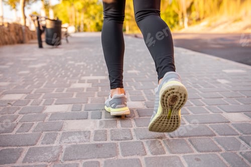 Preview: Close-up of runners sneakers of an athlete running marathon. Womens legs are engaged in jogging