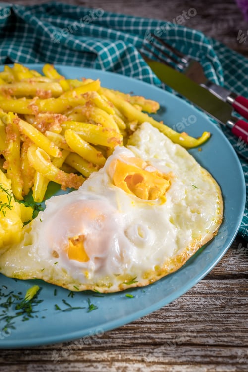 Preview: Fried egg served with boiled potatoes and yellow beans.
