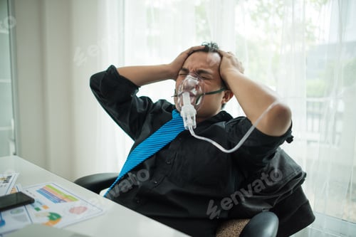 Preview: Business man with suit working with oxygen mask in the office. Sick man work in the office alone
