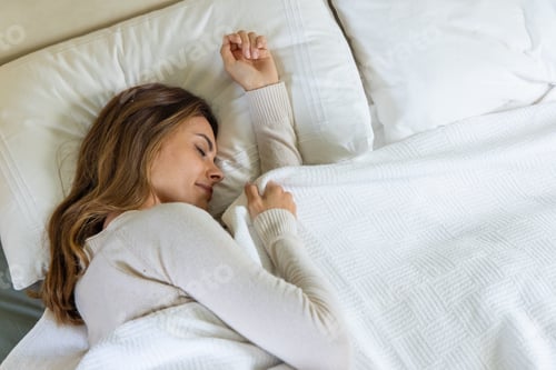 Preview: Woman peacefully sleeping in cozy bed, enjoying restful night at home